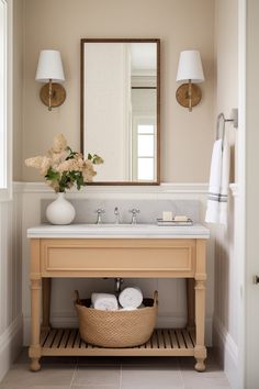 a bathroom with a sink, mirror and basket on the counter in front of it