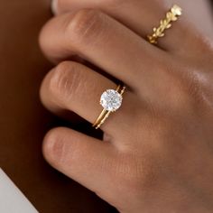 a woman's hand holding a diamond ring