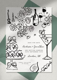 a wedding card with black and white ink on it, surrounded by flowers and wine glasses