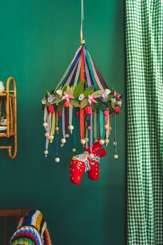 a room with green walls and a colorful chandelier hanging from the ceiling