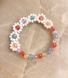 Rainbow Flower Beaded Bracelet 🌈 Danity and cute with a pop of color ✨ Made with shimmer multi colored beads and white seed beads. See other listings for other color options or message us.  CARING TIPS FOR YOUR JEWELRY ⭐️Treat and store with care. ⭐️ For longevity, avoid exposing your jewelry to water. ⭐️ Avoid having direct contact with lotions, perfumes, sanitizers as these chemicals may cause discoloration of your jewelry. Flower Shaped Beaded Bracelets For Beach In Spring, Spring Beach Beaded Bracelets With Flower Shape, Summer Flower Beaded Bracelets, Flower Shaped Beaded Bracelets For Beach, Floral Beaded Bracelets For Beach And Spring, Spring Flower Beaded Bracelets For Beach, White Beaded Bracelets With Flower Charm For Spring, Flower Shaped Beaded Bracelets For Friendship, Handmade White Stretch Bracelet With Flower Design