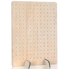 a wooden peg board with two metal hooks on the front and one has holes in it