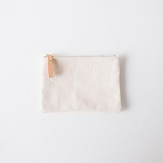 The zip pouch is handmade of heavyweight cotton canvas, with a solid brass zipper that features a leather pull for easy use. It's the perfect accessory to organize items in your tote or to carry on its own. The small zip pouch measures 5.5 inches by 7.5 inches, and the medium zip pouch measures 7 inches by 9.5 inches. Canvas Travel Pouch With Zipper, Canvas Pouch For Everyday Use, Minimalist Rectangular Pouch With Zipper, Minimalist Rectangular Zipper Pouch, Everyday Zipper Pouch Coin Purse, Everyday Canvas Cosmetic Bag With Zipper, Everyday Canvas Bag With Zipper Pouch, Everyday Canvas Pouch With Zipper Closure, Beige Zipper Pouch For Personal Use