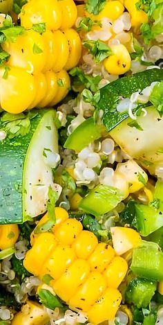 a salad with corn, cucumbers and herbs in it on a white plate