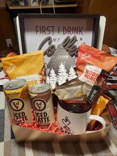 a basket filled with coffee and snacks on top of a table next to a sign