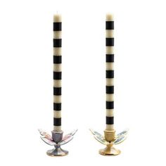 two black and white striped candles with angel wings on each candle holder, both decorated in gold