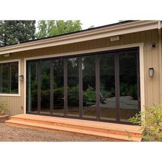 an outside view of a house with sliding glass doors on the front and side windows