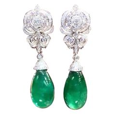 A pair of exquisite earrings boast a classic design that exude timeless elegance. The Emeralds , with their verdant green hue , captivate the eye with their vibrant brilliance . Nestled amongst the emeralds are glistering diamonds , which add a touch of glamour and luxury to the piece. Every detail is carefully crafted to perfection , making these earrings a true treasure to behold. Magnificent earrings come in 18k gold with 2 pieces of adorable Natural Zambian Emeralds, in perfect cabochon cut, spectacular vivid color, fine quality, only Minor treatment, of 50,00 carats, and 264 pieces of Natural Diamonds, of 2,60 carats, F-G color VS clarity. Handcrafted by artisan goldsmith. Complete with AIG report. Wholesale Price. Extremely HIGH QUALITY Product. Earring Video, Verdant Green, 18k Gold Earrings, Zambian Emerald, Emerald Stone, Modern Earrings, Zambia, Chandelier Earrings, Modern Jewelry