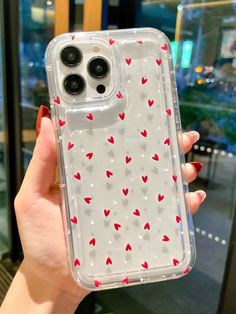 a woman holding up a clear case with hearts on it