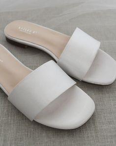 Classic slide flat sandals for casual and dressy look. Simple and easy wear for brides, bridesmaids and wedding parties.DETAILS:COLORS AVAILABLE: Ivory, Light Blue, White, Pink, and ChampagneUPPER: Synthetic upper and liningMATERIALS: Mandmade outsole STYLE NAME: EVELYN Summer Flat Heel Bridesmaid Wedding Shoes, Elegant White Open Toe Slides, Summer Wedding Shoes With Flat Heel For Bridesmaids, Chic Wedding Sandals For Summer, Summer Bridesmaid Wedding Shoes With Flat Heel, Flat Summer Wedding Shoes For Bridesmaids, Chic Summer Wedding Shoes, Flat Heel Slides For Summer Parties, Summer Wedding Shoes With Low Heel