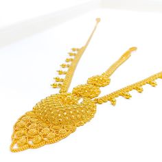 This exquisite 22k gold matha patti, weighing 29.2 grams, features a radiant yellow gold finish and intricate detailing. The tikka measures 5.5 inches in length, while the side chains are 6.5 inches long, ensuring a perfect fit and elegant drape. The matha patti is secured with a hook clasp style, adding ease of wear. Ideal for those who appreciate traditional and ornate jewelry, this piece combines timeless beauty with detailed craftsmanship, making it a stunning choice for any special occasion Gold Mantika, Gold Chik Patti Necklace, Gold Cutdana Tikka Temple Jewelry, Gold Mang Tika, Gold Matha Patti, Ornate Jewelry, Matha Patti, Bridal Jewelry Necklace, Precious Stones Rings