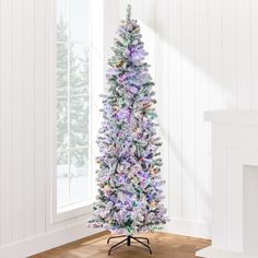 a white christmas tree with purple and green decorations