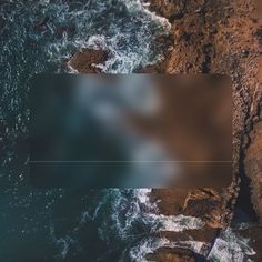 an aerial view of the ocean and rocks