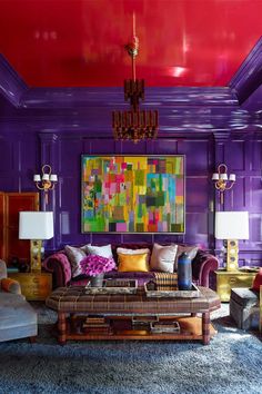 a living room with purple walls and furniture