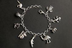 A collection of silver plated Australian wildlife themed charms have been dispersed around a shimmering silver plated bracelet chain in this handmade charm bracelet. This Australian wildlife charm bracelet is then completed with a lobster clasp and a 1/2 inch of chain at the end for adjustable sizing. Charms in this bracelet include a kangaroo charm, echidna charm, crocodile charm, koala charm, platypus charm, emu charm, wombat charm, gecko charm, and a sea turtle charm. ● Sizing ● To determine Nickel Free Novelty Bracelet Jewelry, Novelty Charms Bracelet Jewelry, Novelty Jewelry Charms Bracelet, Novelty Silver Hypoallergenic Bracelets, Silver Novelty Jewelry With Lobster Clasp, Silver Novelty Charm Bracelet As A Gift, Silver Novelty Charm Bracelet Gift, Handmade Novelty Silver Bracelets, Novelty Silver Charm Bracelet Gift