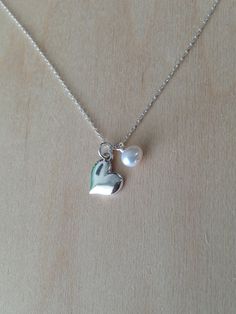 "Delicate. Beautiful. Elegantly Simple. Sterling Silver 9mm (0.35 inches) heart pendant necklace. This lovely heart pendant is accented by a small pearl or 6mm Swarovski crystal charm of your choice and hangs delicately from a Sterling Silver chain. Shown in 16\" length with a pearl accent. Please message me if you would like more than the quantity listed. I can produce custom orders of any quantity within a week. Visit my shop: http://www.etsy.com/shop/Jadedslo All items are handmade and I guar Gold Moon Necklace, Sterling Silver Heart Necklace, Necklace Birthstone, Gold Heart Necklace, Gold Moon, Silver Heart Necklace, Solid Gold Jewelry, Crystal Charm, Moon Necklace