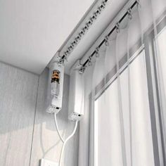 an electrical outlet attached to the side of a wall next to a window with curtains