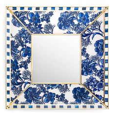 a blue and white flowered plate with a gold border around the edge, holding a square mirror