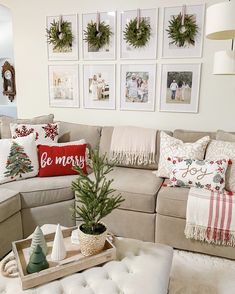 a living room filled with lots of furniture and christmas wreaths on the wall above it