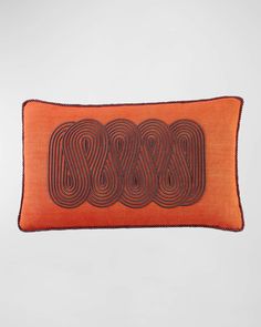 an orange and black pillow with three circles on the front, two in the back