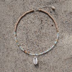 Originally founded as an arts colony, Laguna Beach is a mix of chill beach town and funky bohemian culture, offering some of the clearest blue water and the most relaxing days Southern California has to offer. MATERIALS blue and natural colored Amazonite with cowrie shell and natural wood on a 15" wire, finished with a 1.5" sterling silver extender chain with a ring clasp and tulip shell. Every stone is unique, which means that each bracelet is too. You can expect your jewelry to be one of a kin Bohemian Shell-shaped Beaded Necklace For Vacation, Handmade Multi-strand Shell Necklace For Beach, Ocean-inspired Shell Necklace With Colorful Beads, Handmade Turquoise Shell Necklace Ocean-inspired, Handmade Turquoise Shell Necklace, Ocean-inspired, Bohemian Culture, Clear Blue Water, Cowrie Shell, Relaxing Day