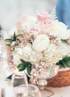 a vase filled with lots of white and pink flowers