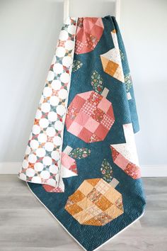 two quilts are hanging on the back of a chair