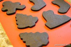 chocolate cookies are shaped like shapes on an orange tray