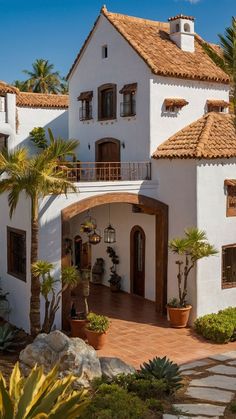 a large white house with palm trees in the front yard