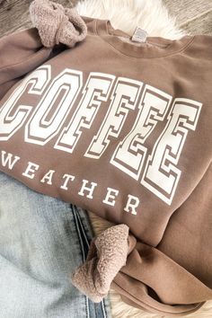 Wrap yourself up in warmth with this cozy Coffee Weather Sweatshirt. The mid-weight fabric and soft fleece lining make it perfect for those blustery days. Plus, you'll look stylish with the bold, black puff print graphic on cocoa brown – can't beat that! So put on your Coffee Weather Sweatshirt and brew up some hot fun! Unisex sizing. True to size! It is not that stretchy so size up if needed! 50% Cotton 50% polyester To extend the life of your graphic sweatshirt please wash inside out and do no Coffee Colored Tops With Letter Print For Fall, Brown Loungewear Tops For Winter, Coffee Letter Print Tops For Fall, Brown Sporty Sweatshirt For Fall, Brown Casual Sweatshirt With Relaxed Fit, Comfortable Winter Tops With Graphic Print, Comfortable Graphic Print Tops For Winter, Sporty Brown Sweatshirt For Fall, Comfortable Graphic Print Winter Tops