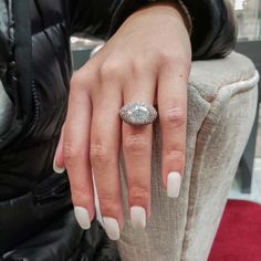 a woman's hand with a diamond ring on her finger, sitting in a chair