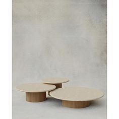 two tables sitting on top of each other in front of a concrete wall and floor