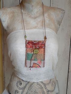 a mannequin wearing a white top with a necklace hanging from it's chest