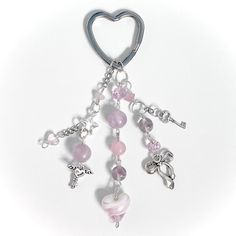 a heart shaped key chain with charms hanging from it's side on a white background