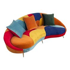 a multicolored couch with several pillows on it's back and sides, sitting in front of a white background