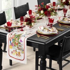 a dining room table set for christmas dinner with red and white decorations on the table