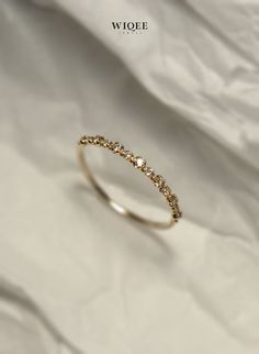 an image of a gold ring with diamonds on white cloth background, close up photo