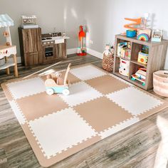 a child's play room with wooden toys on the floor and rugs in front of it