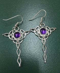 I've fabricated these Celtic Trinity Knot earrings in sterling silver featuring two gorgeous 8mm round AA grade Amethyst cabochon gemstones. These earrings are approximately 2 inches in length and are made with three small trinity knots surrounding the center gemstone, with a twist wire accent which spirals downward. The ear wire is also sterling silver. Click the link for a matching pendant which can be found here: https://www.etsy.com/listing/203908168/celtic-trinity-knot-sterling-silver?ref=s Purple Round Spiritual Earrings, Spiritual Round Purple Earrings, Spiritual Purple Round Earrings, Silver Amethyst Wire Wrapped Earrings, Sterling Silver Pierced Round Pendant Jewelry, Purple Round Pierced Earrings, Spiritual Style Wire Wrapped Round Earrings, Wire Wrapped Amethyst Round Earrings, Wire Wrapped Round Spiritual Earrings