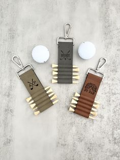 four different types of golf tees and ball markers on a concrete surface, with one being used as a keychain