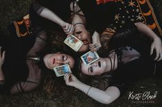 three beautiful young women laying on top of each other holding playing cards in their hands