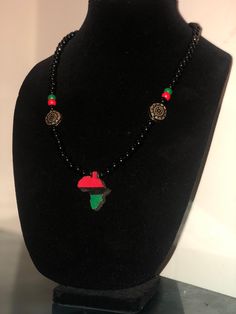 Red black and green Africa pendant. Handmade and hand painted. Casual Black Pendant Jewelry, Black Hand Painted Pendant Jewelry, Hand Painted Black Pendant Jewelry, Adjustable Hand Painted Black Necklace, Artistic Black Pendant Necklace, Artisan Black Beaded Necklace For Gift, Artistic Black Pendant Jewelry, Casual Black Beaded Necklace As Gift, Casual Black Beaded Necklace For Gift