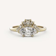 a yellow gold engagement ring with an oval cut diamond in the center and side stones