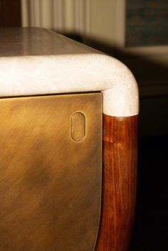 a close up view of the top of a gold and white table with a wooden base