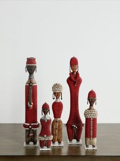 a group of african dolls sitting on top of a wooden table