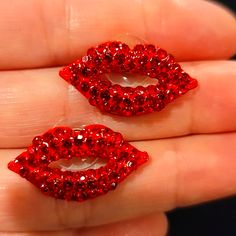 two red lips shaped like lipstick on top of each other in someone's hand