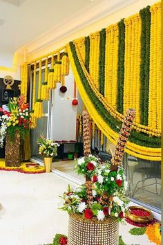 a room decorated with flowers and garlands on the wall, along with other decorations