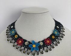 a black and blue flower necklace on a mannequin