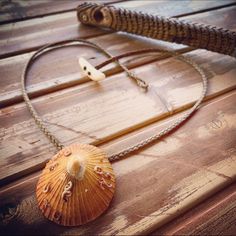 an orange shell is sitting on top of a wooden table next to a snake's tail