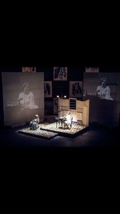 the stage is set up for an event with two people on chairs and one person sitting in